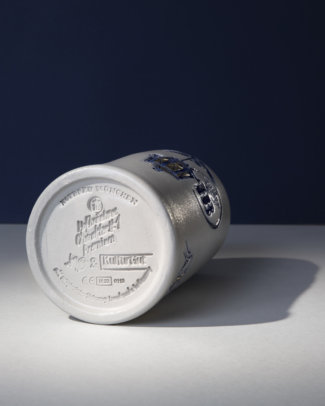 Unterseite eines Bierkrugs mit eingeprägter Bodenmarke und Logo.