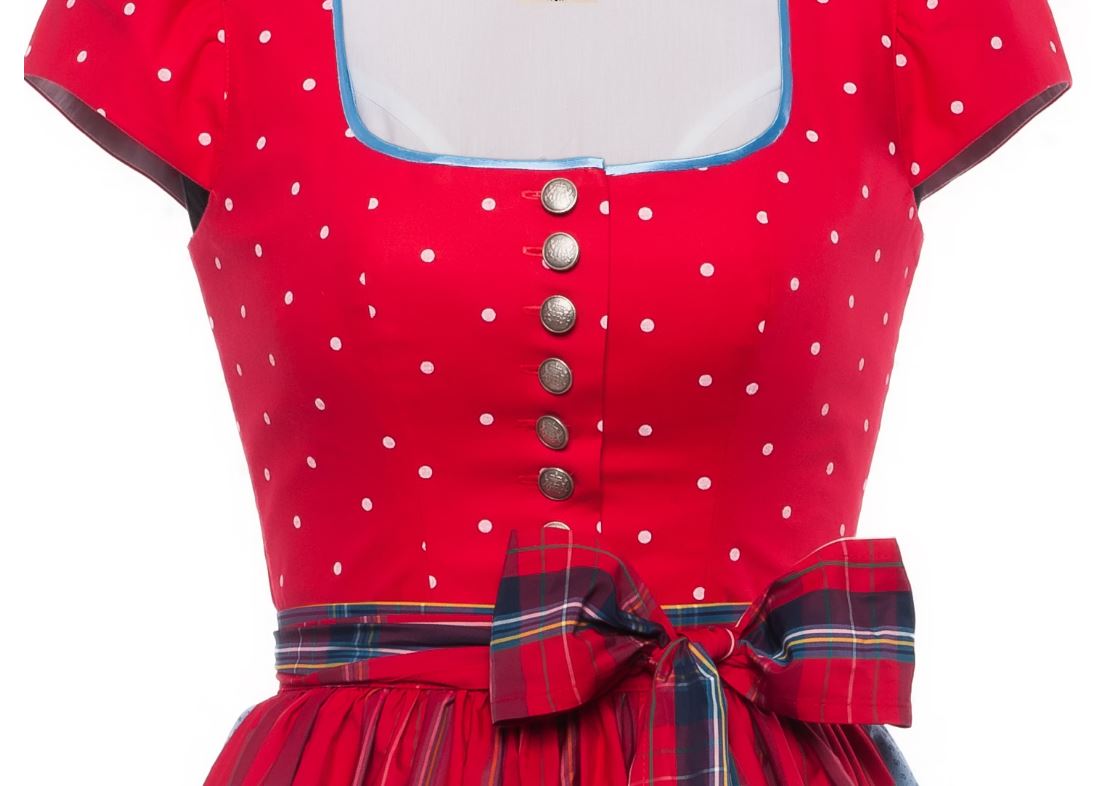 Detailaufnahme eines Dirndls: rotes Oberteil mit weißen Punkten, silbernen Knöpfen und quadratischem Ausschnitt, dazu kariertes Schürzenband mit Schleife.