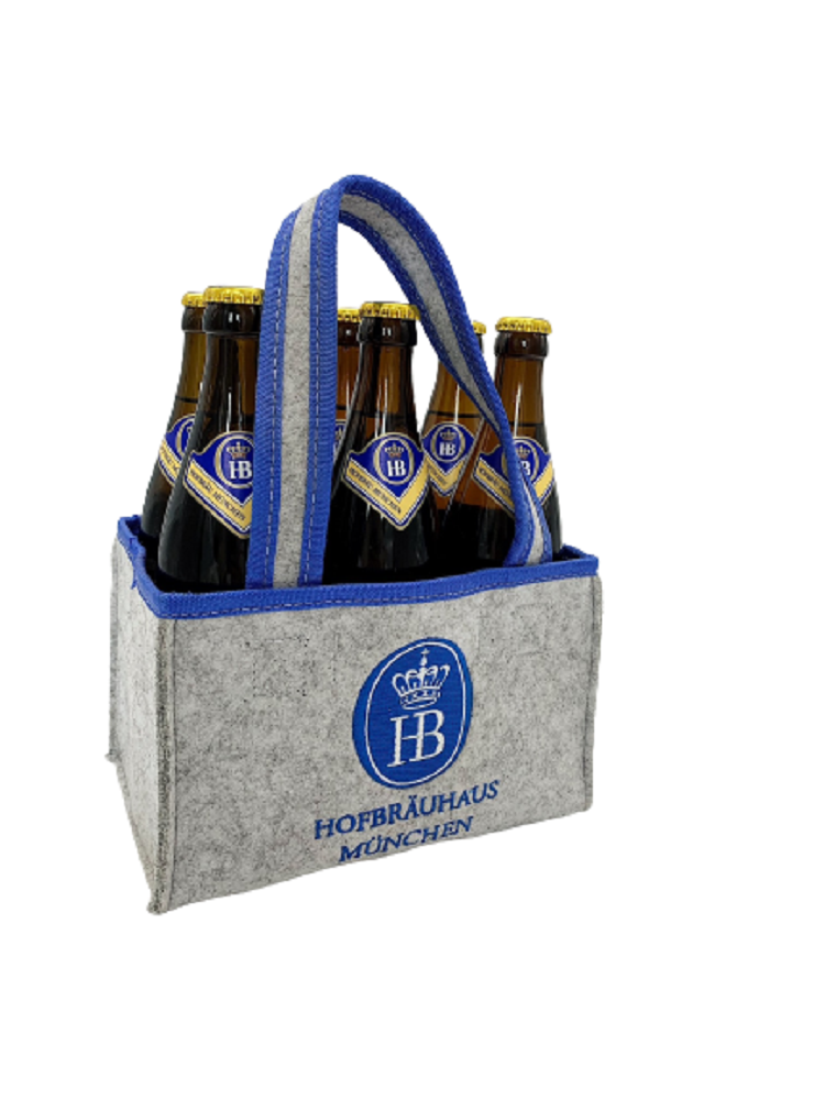 „Grauer Bierträger aus Filz mit blauer Umrandung, befüllt mit sechs braunen Glasflaschen Hofbräuhaus München Bier. Der Träger hat zwei Henkel und trägt das Hofbräuhaus München Logo auf der Vorderseite.“